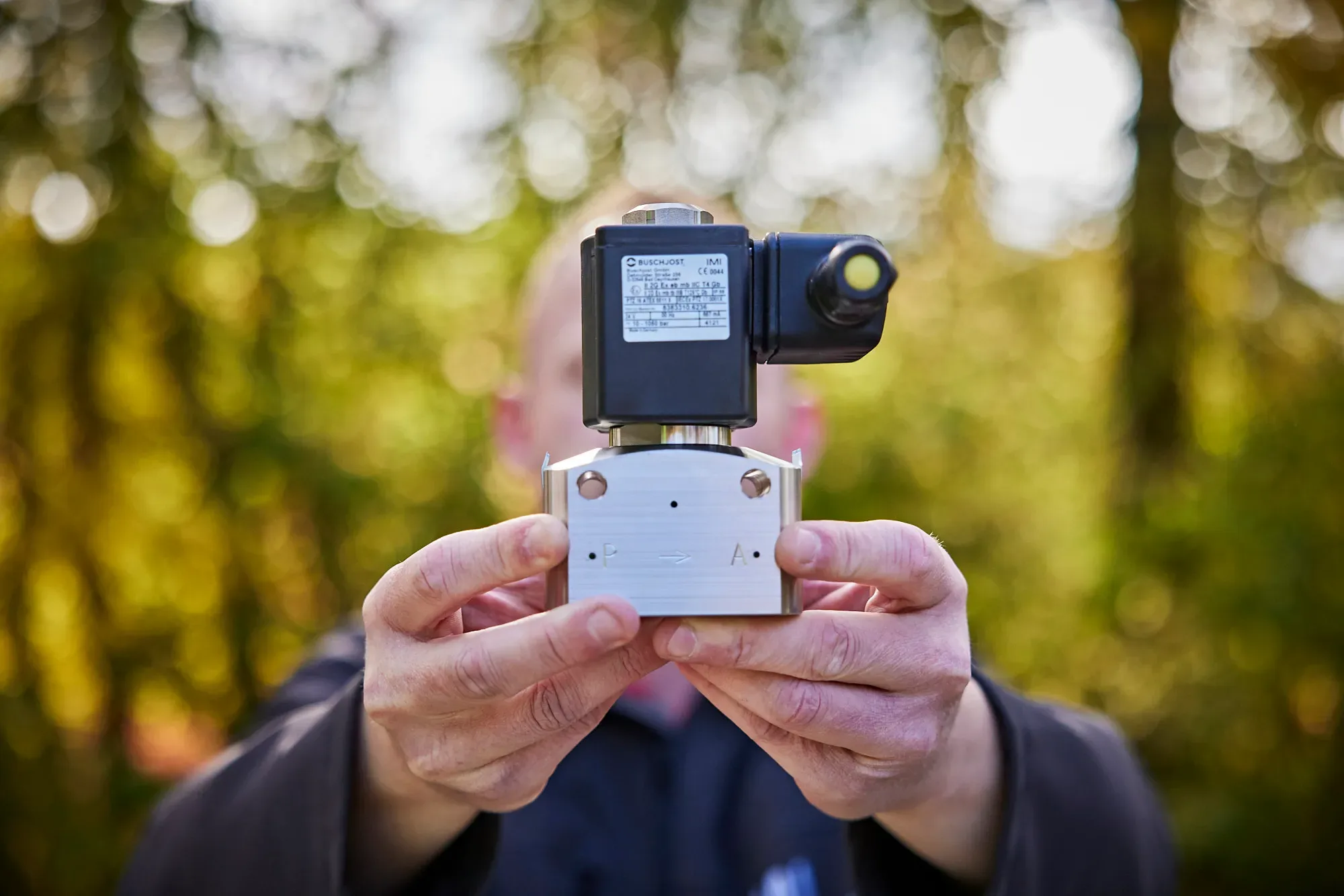 Man holding up a Buschjost fluid control valve